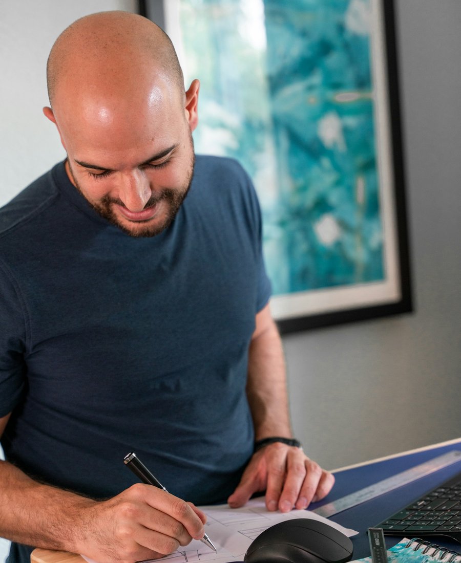 A business owner reviewing and signing a written proposal at a bright desk